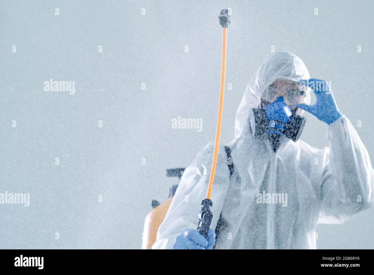 image of an employee of the sanitary service with a can of disinfectant. Stock Photo