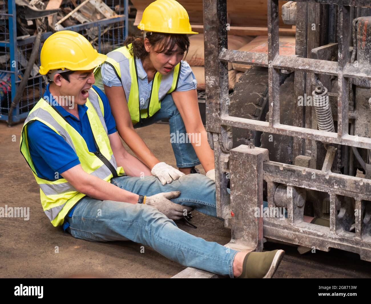 Female workers are banning cargo drivers from continuing to drive due to an accident, a male worker's leg gets stuck in a forklift's wheel while worki Stock Photo