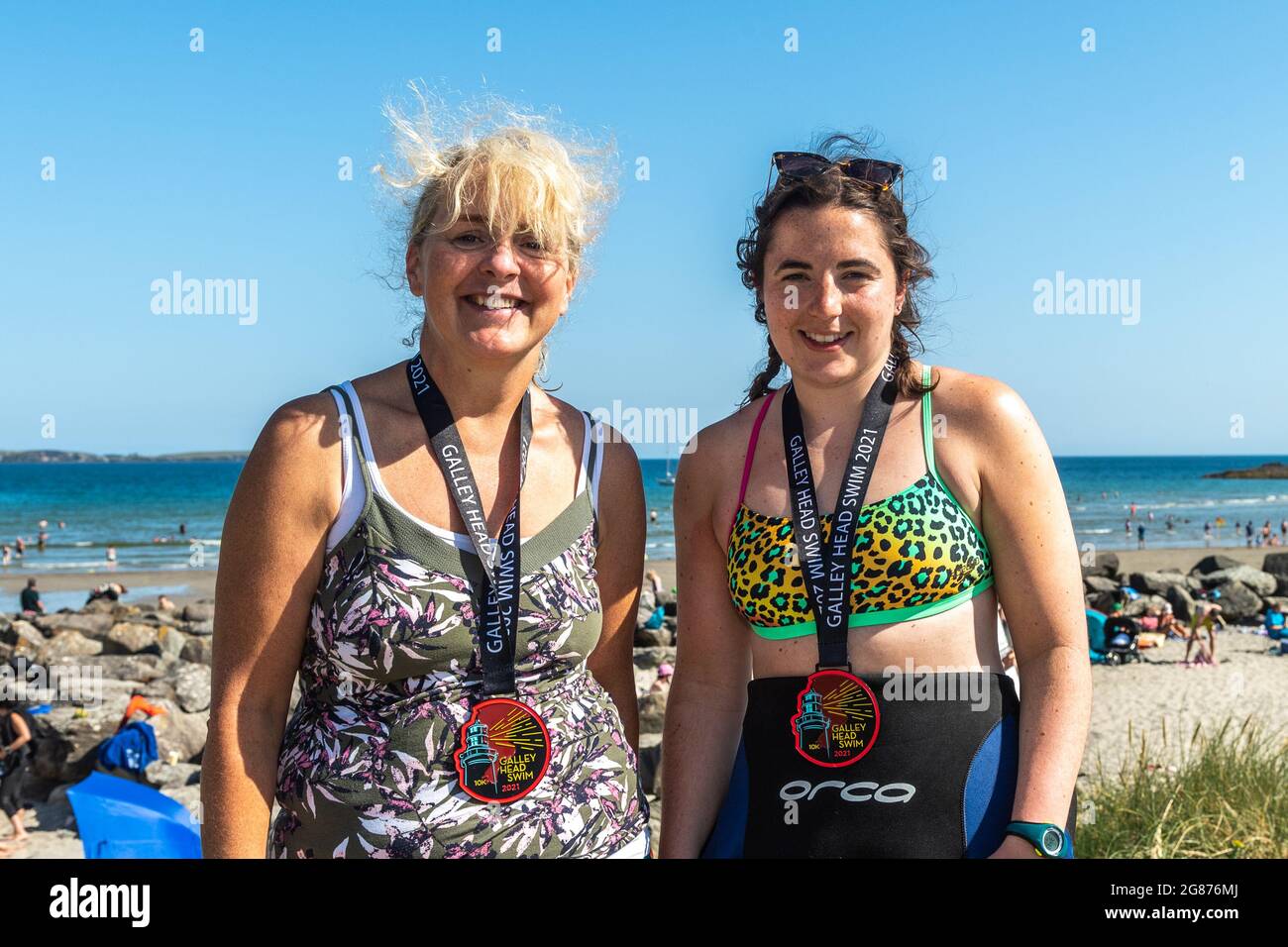 Rosscarbery, West Cork, Ireland. 17th July, 2021. Temperatures hit 27C in Rosscarbery today with The Warren Beach packed with sun seekers. The Galley Head swimtook place today where competitors swam from Red Strand to The Warren Beach, a distance of 10KM. Pictured after the swim with their medals are Hetty Walsh, Clonakilty and Jane O'Donovan, Ballineen. Credit: AG News/Alamy Live News Stock Photo