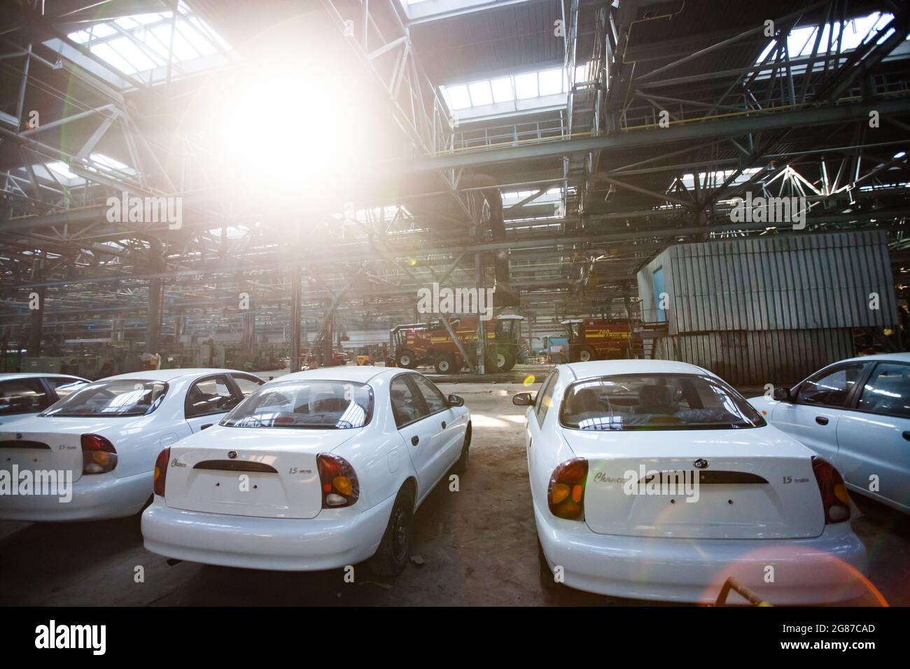 Kostanay,Kazakhstan,May14,2012:Saryarkaavtoprom and AgroMashHolding auto-building plant workshop. New ZAZ Chance auto.Farm harvester on backdrop. Stock Photo