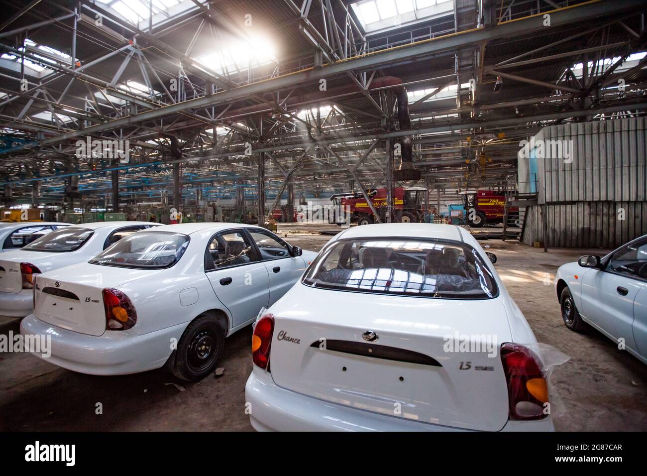 Kostanay,Kazakhstan,May14,2012:Saryarkaavtoprom and AgroMashHolding auto-building plant workshop. New ZAZ Chance auto.Farm harvester on background. Stock Photo