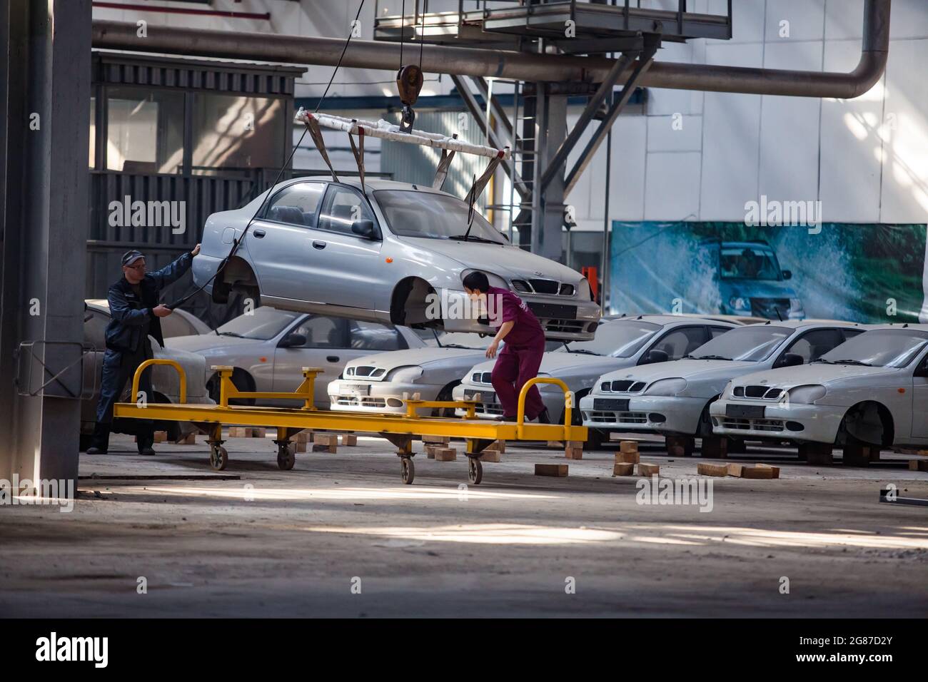 Kostanay,Kazakhstan,May14,2012:Saryarkaavtoprom auto-building plant. ZAZ Chance cars production. Moving car body on hoist to assembling place. Stock Photo