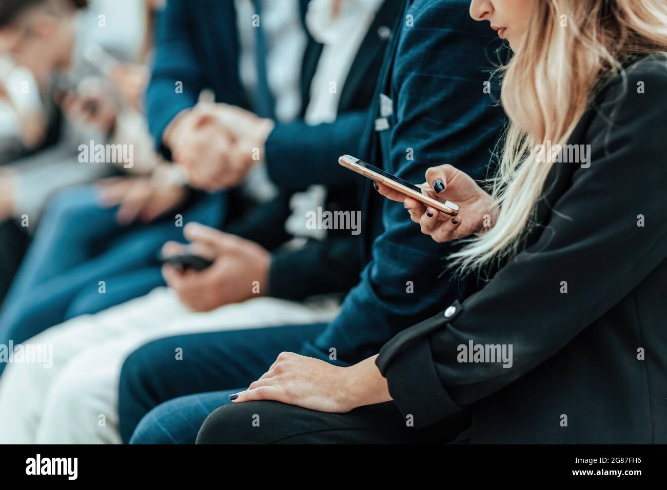 background image of a group of young people sitting in a queue Stock Photo