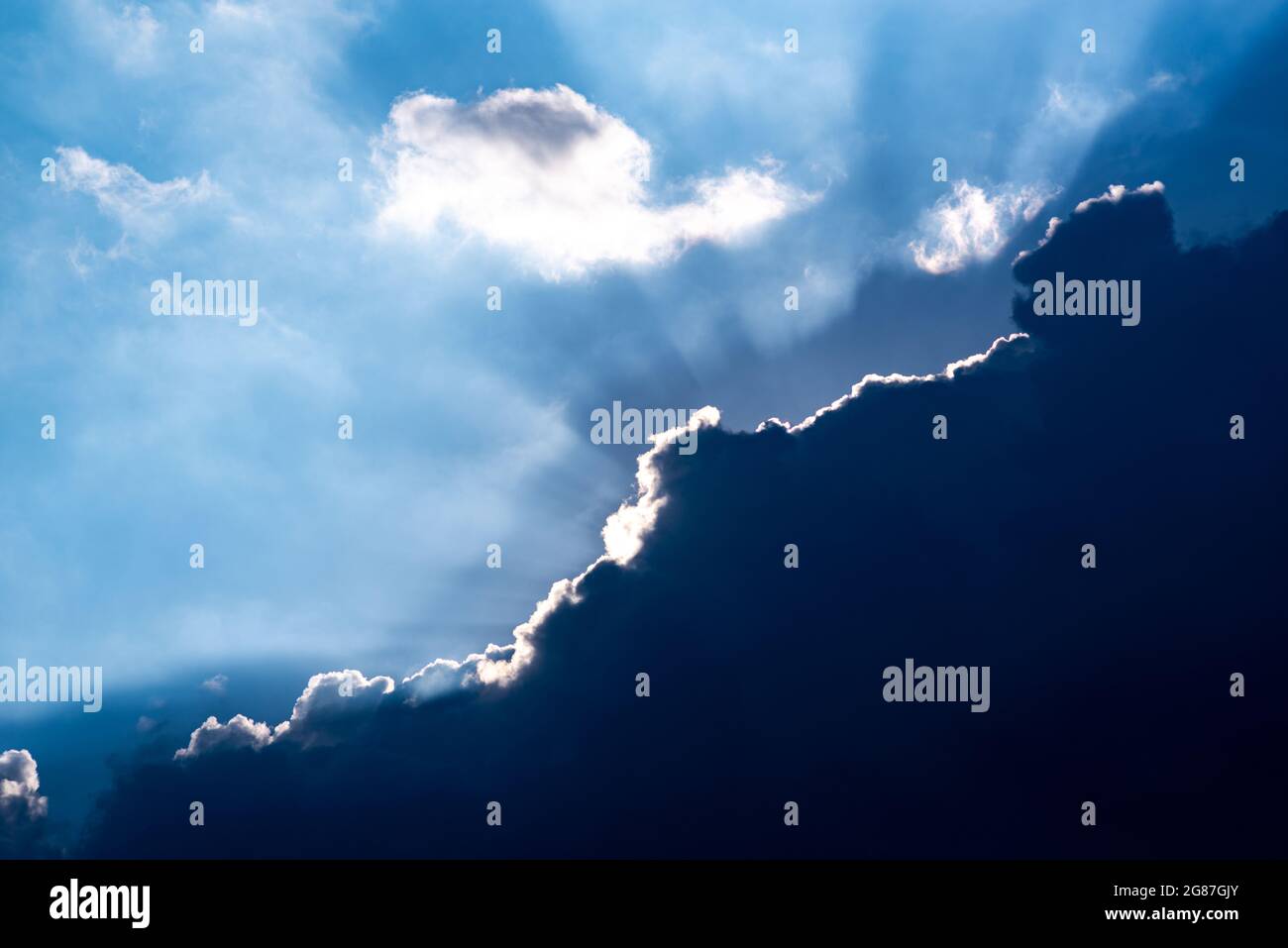 sunbeams behind a dark cloud Stock Photo