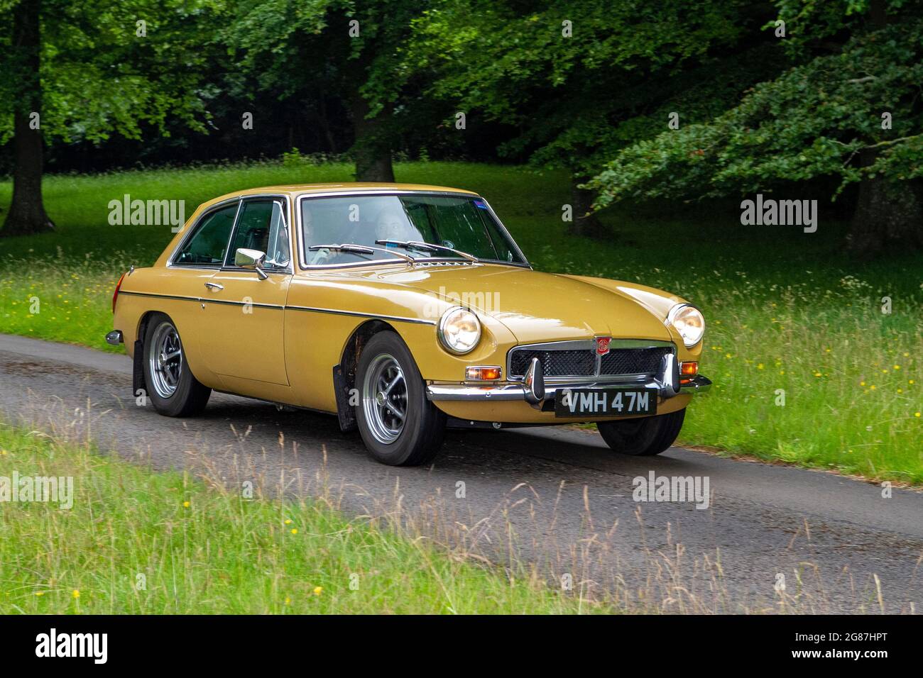 1974 70s,1970s gold British MG BGT at ‘The Cars the Star Show” in Holker Hall & Gardens, Grange-over-Sands, UK Stock Photo