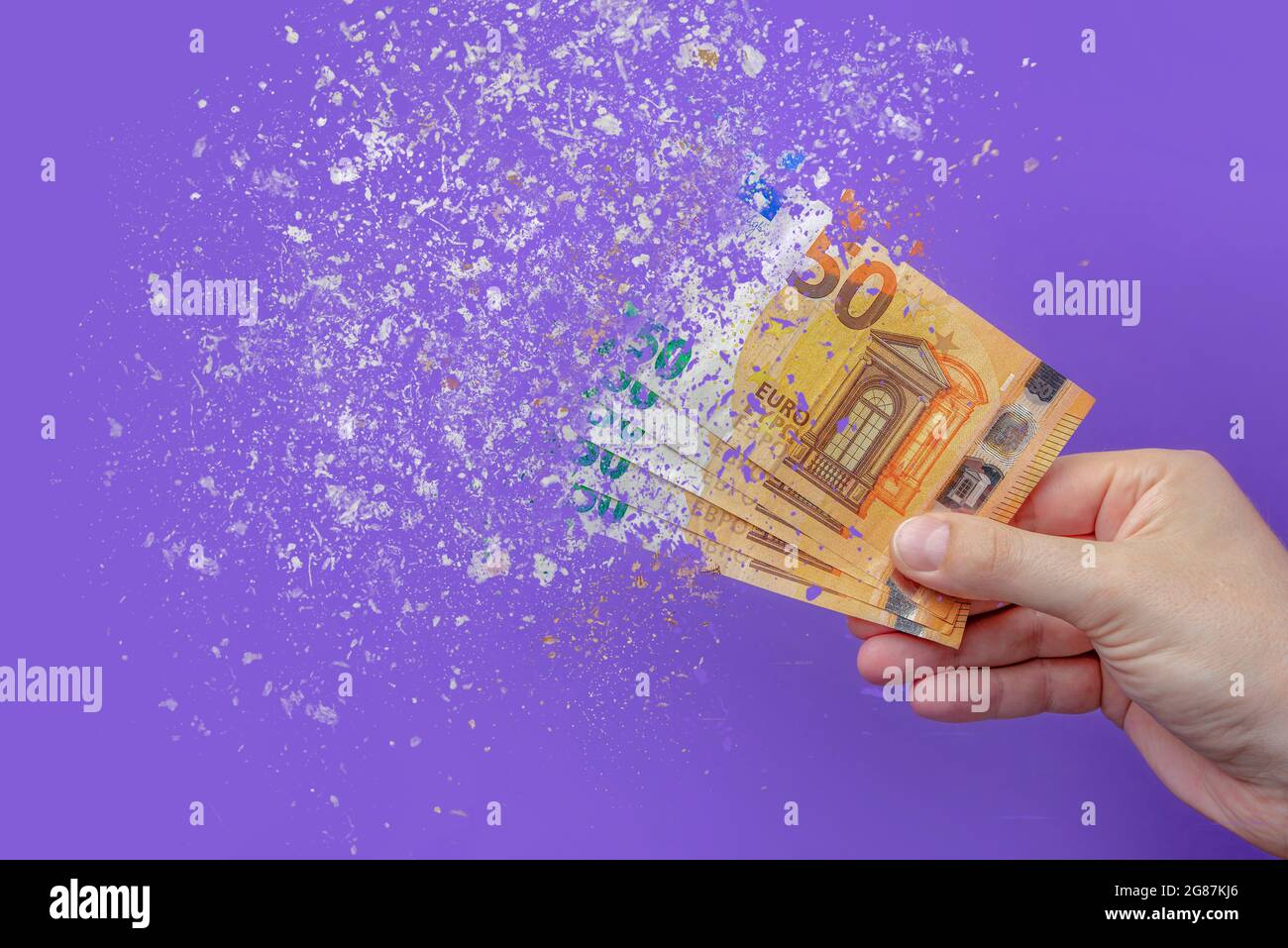 inflation euro . Inflation in Europe, hyper inflation. Banner with purple background. Fifty euro banknotes sprayed in the hand of a man on a purple Stock Photo