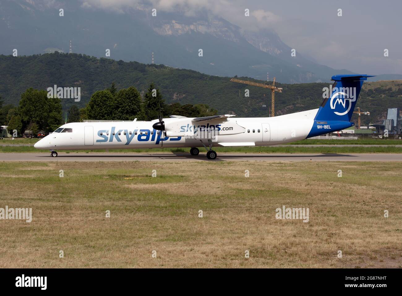 The first Sky Alps (Luxwing) Bombardier Dash 8-400 taxiing at Bolzano airport coming from Ibiza as a summer charter flight. Stock Photo