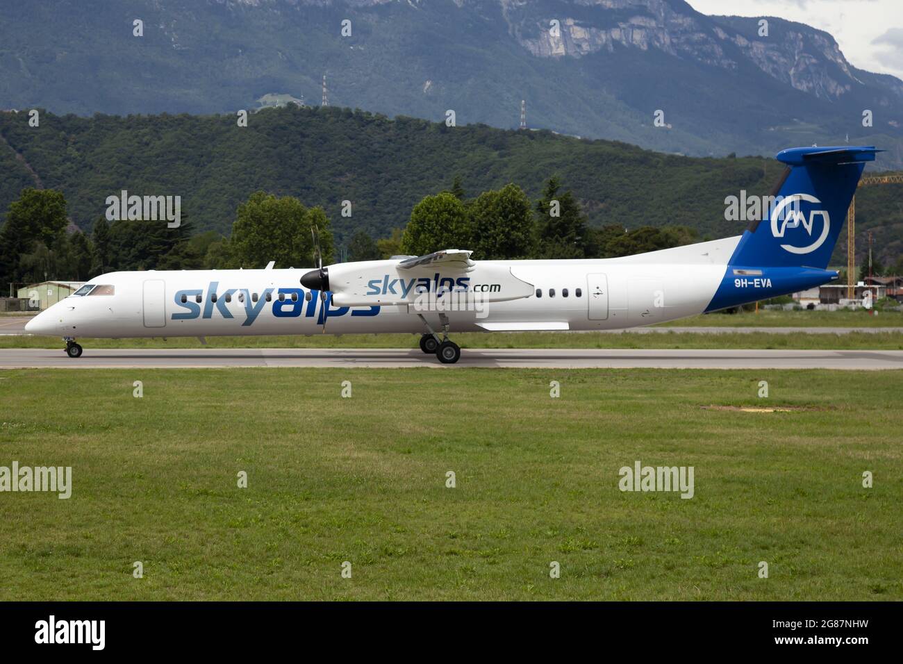 The second Sky Alps (Luxwing) Bombardier Dash 8-400 taxiing at Bolzano airport coming from Olbia as a summer charter flight. Stock Photo