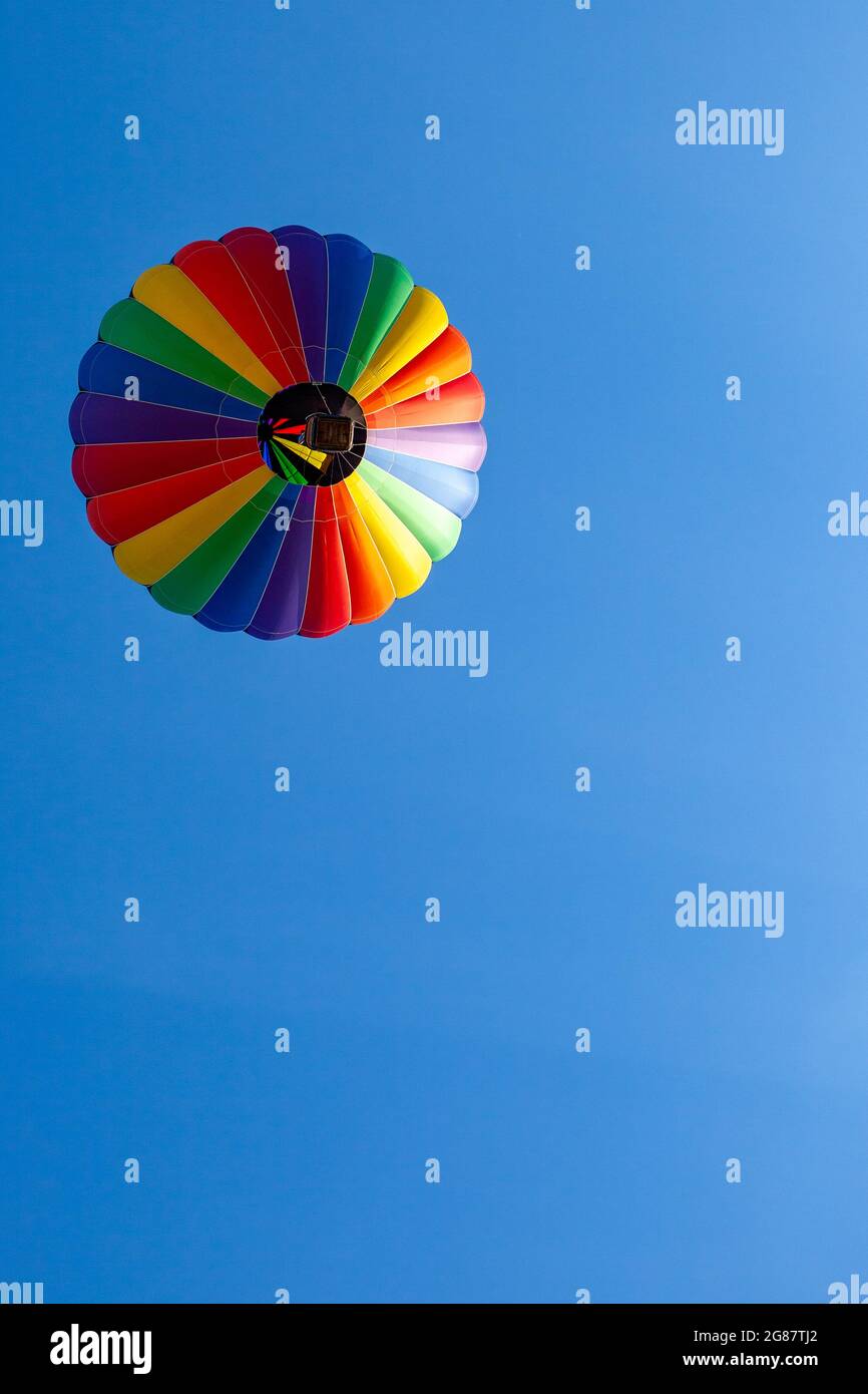 Colorful hot air balloon floating in a clear blue sky with copy space ...