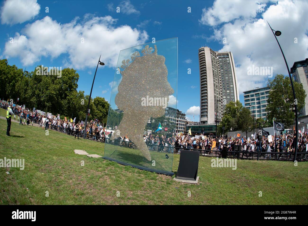 One Million Queen Sculpture with animal rights protesters marching behind Stock Photo