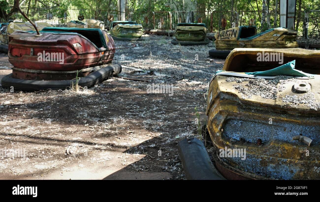 A closeup of abandoned bumper cars in an old amusement park in the