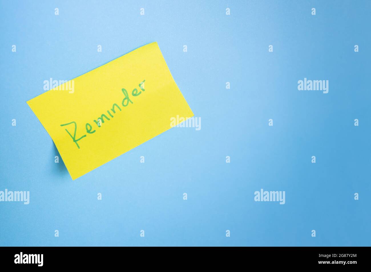 Yellow adhesive note on blue light background. Minimalist concept. Copy-space Stock Photo