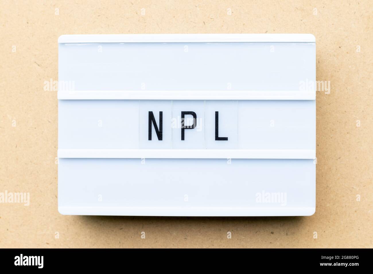 White lightbox with word NPL (Abbbreviation of Non Performing Loan, Non-Patent Literature) on wood background Stock Photo