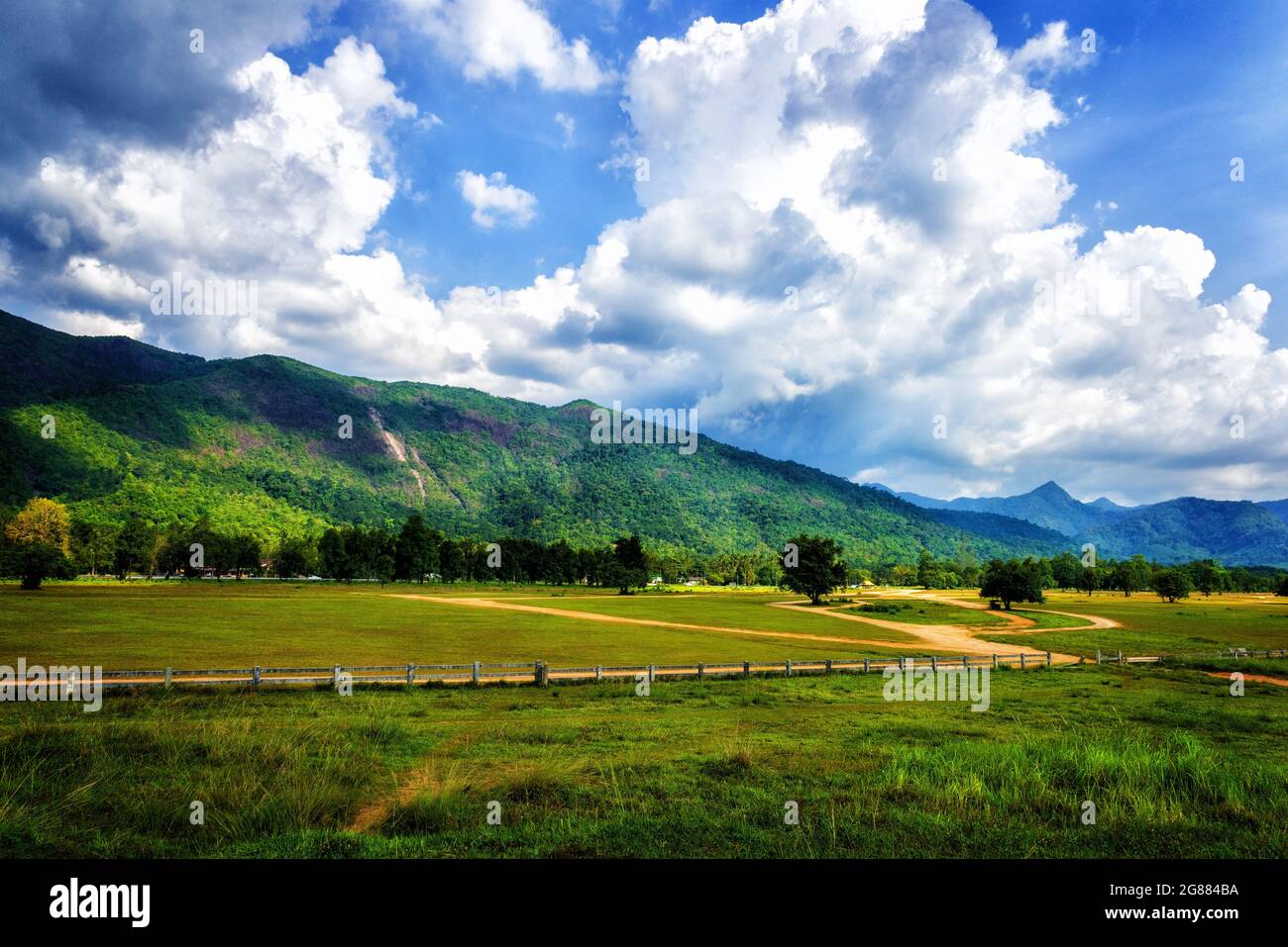 beautiful country scene in cloudy day with mountain range in the background. Stock Photo