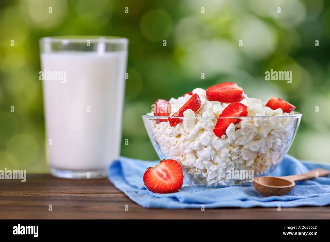 yogurt and cottage cheese with fresh strawberry on table outdoors Stock Photo