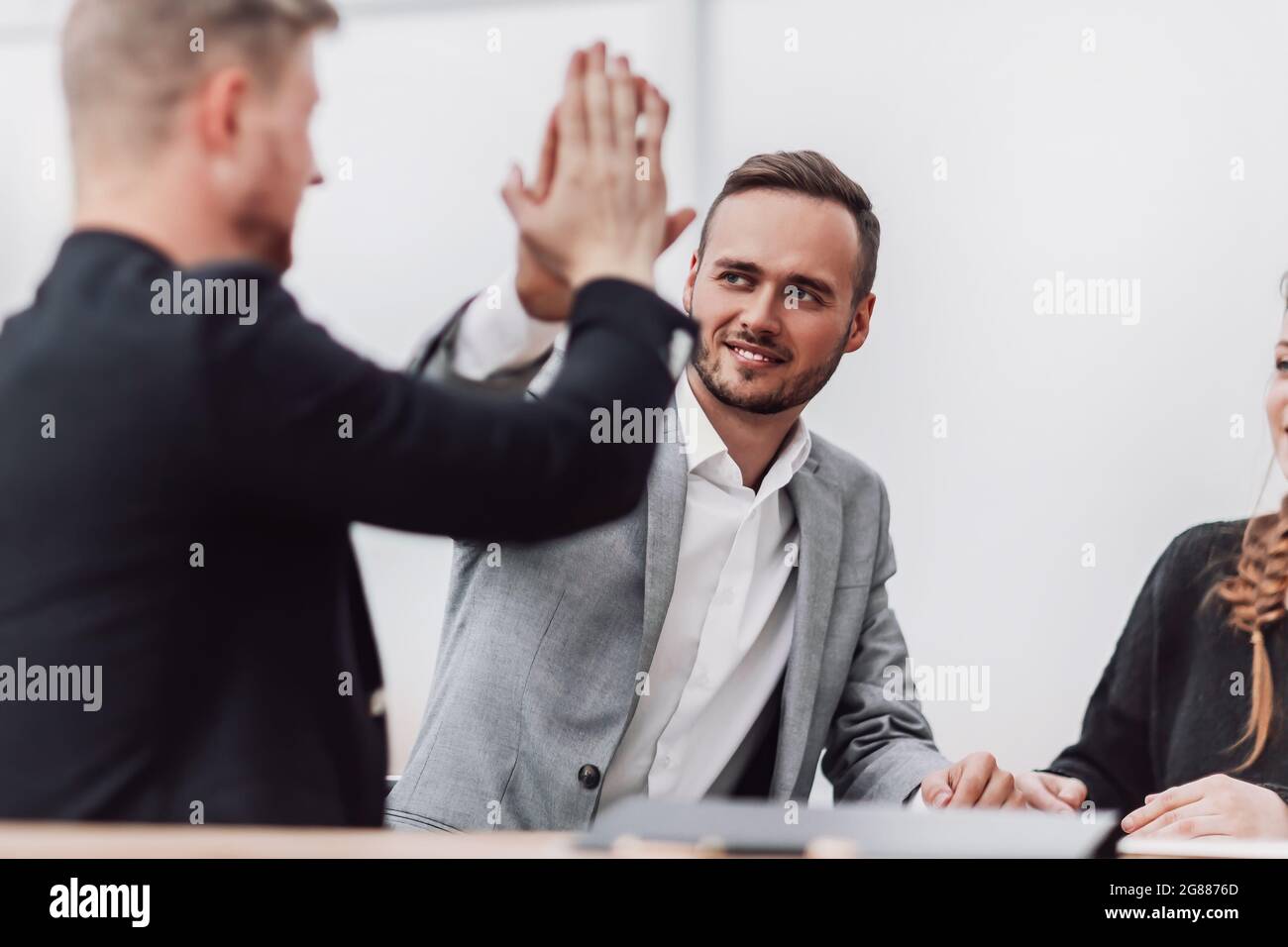 young employees giving each other a high five Stock Photo