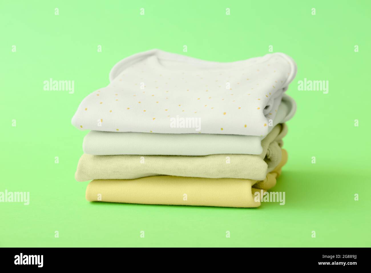 Stack of baby clothes on color background Stock Photo - Alamy