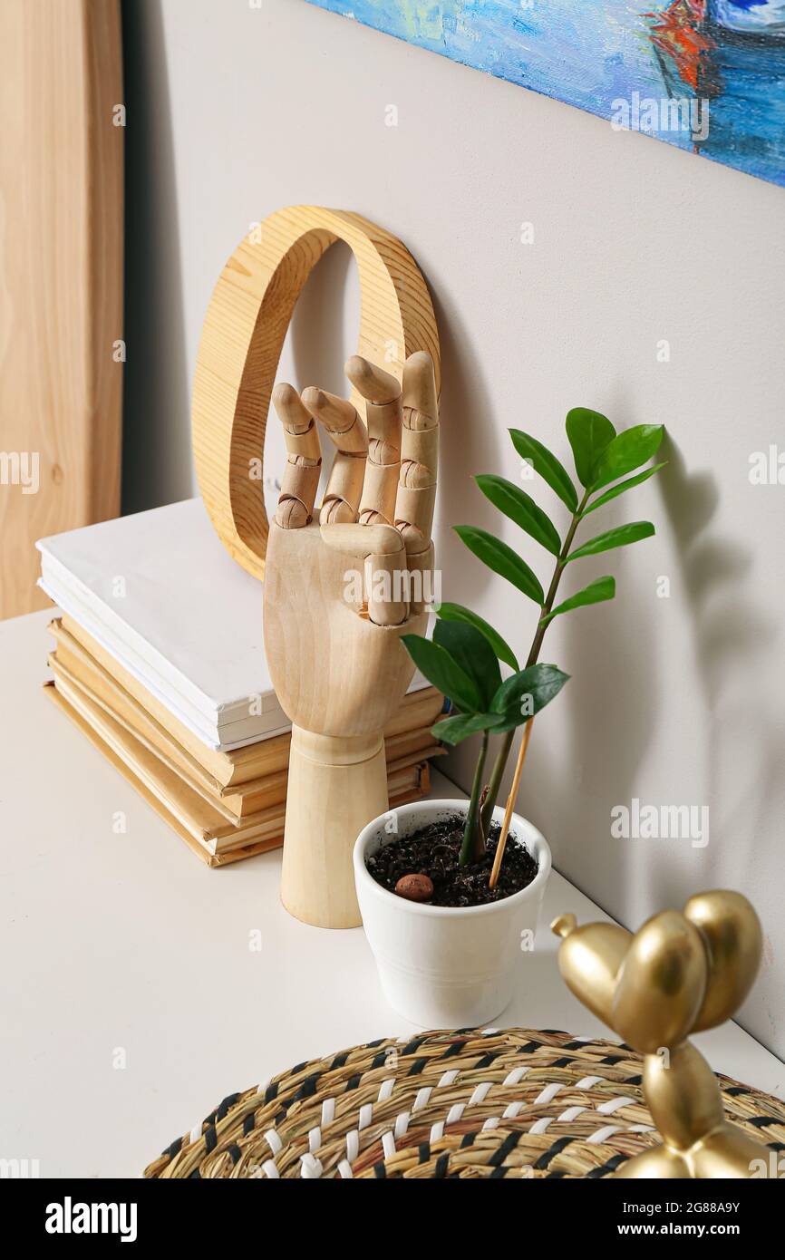 Wooden hand, books and decor on table Stock Photo - Alamy