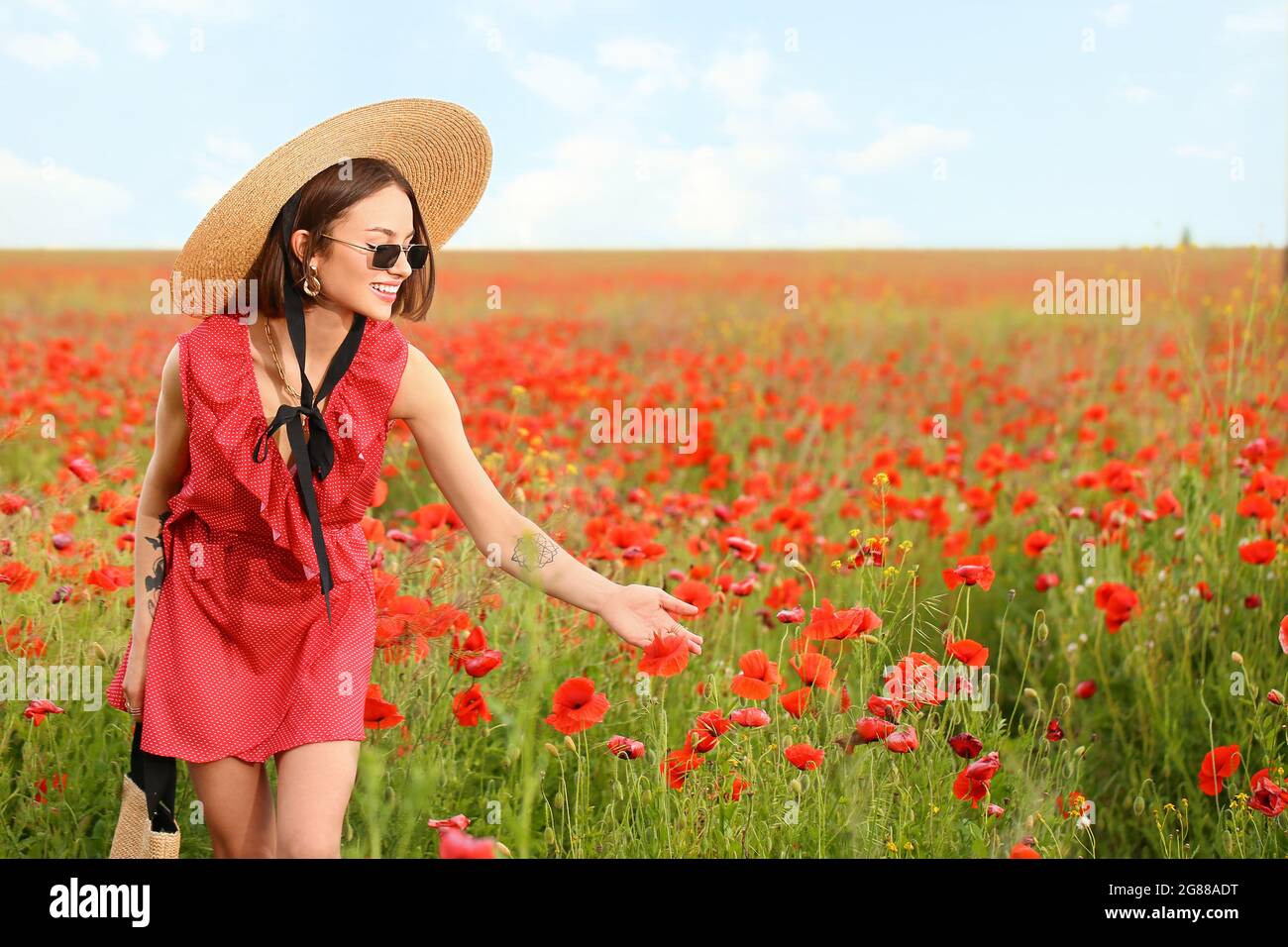 Beautiful young woman in poppy field Stock Photo - Alamy