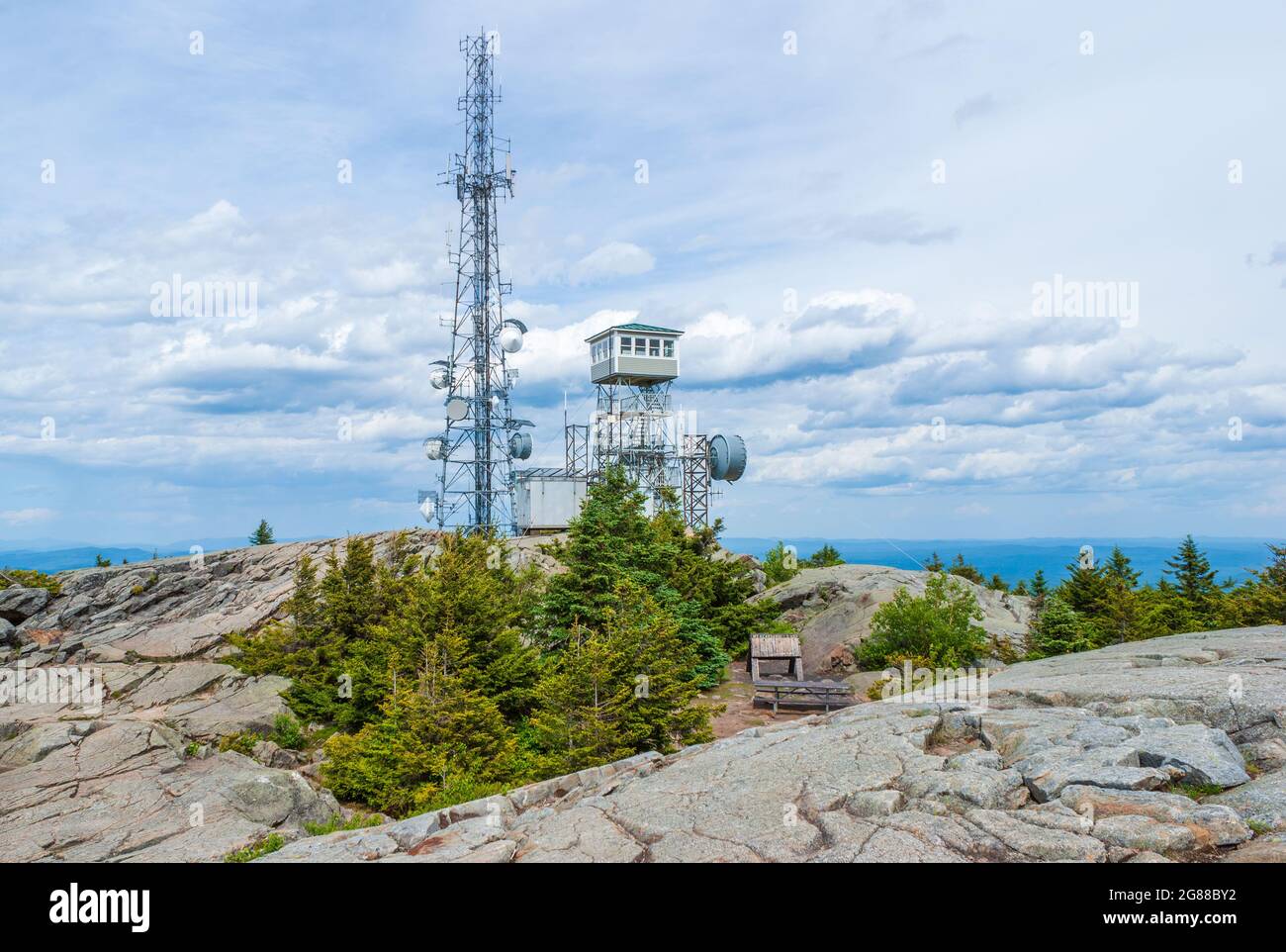 The fire tower on the summit of Mount Kearsarge, New Hampshire. Antennas on a radio repeater tower. Rocky granite outcrop and stunted spruce trees. Stock Photo