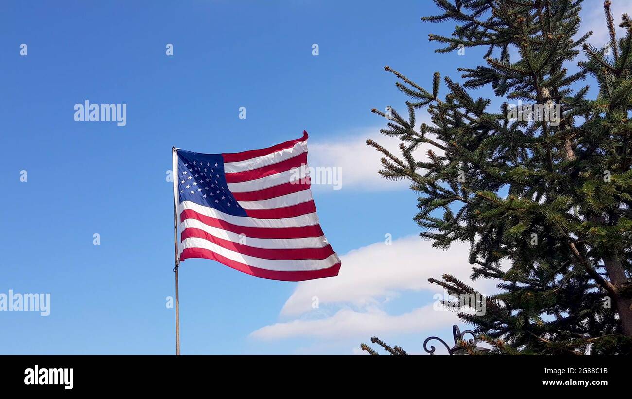 American Flag blowing in the wind with a blue sky background. USA ...