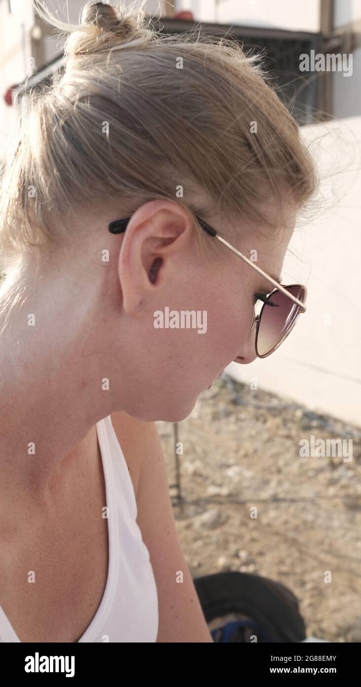 Caucasian Female Blonde Hair Pale Complexion Middle Aged Sunglasses Looking Down Stock Photo