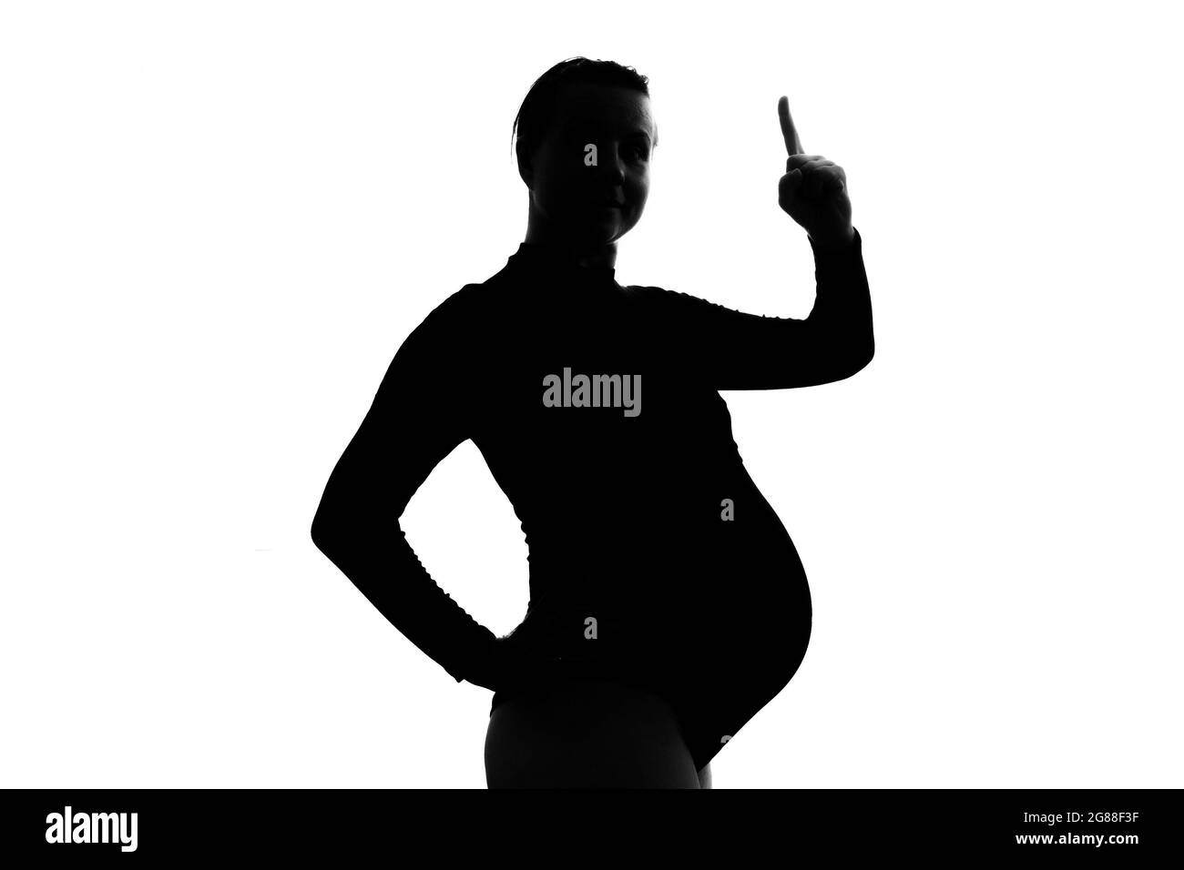 Pregnant woman raising index finger up giving advice or pointing on important information. Stock Photo