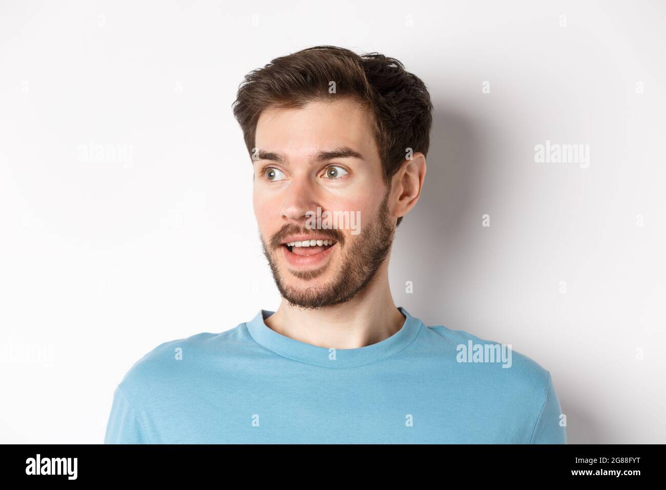 Close-up of surprised and excited bearded man, looking left with opened ...