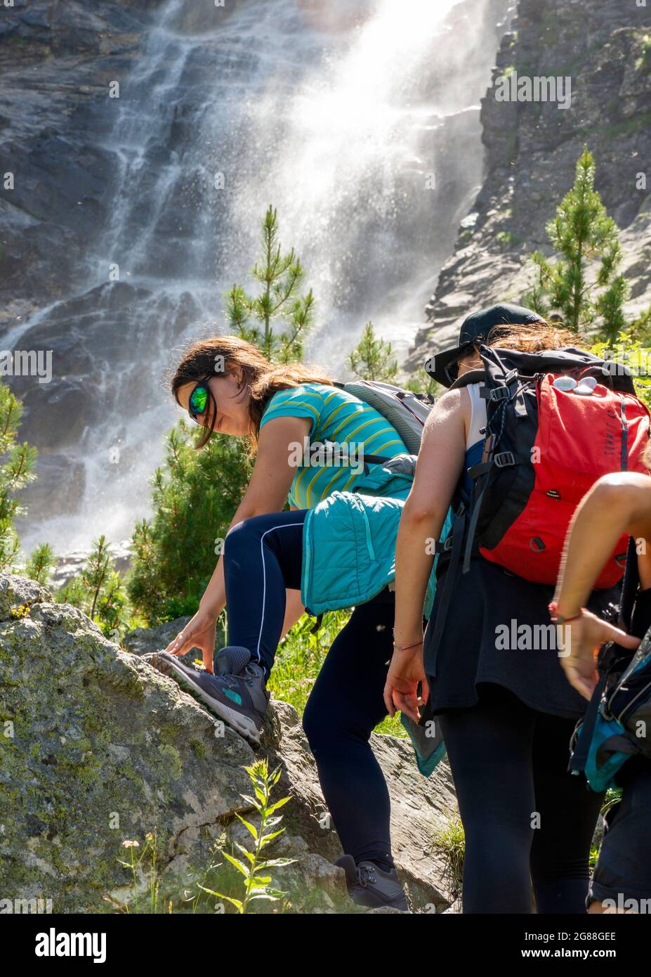 Mountain hiking in Bulgaria. Female hikers backpackers at the Skakavitsa Waterfall as the highest waterfall in Rila Mountain, Bulgaria, Balkans Stock Photo