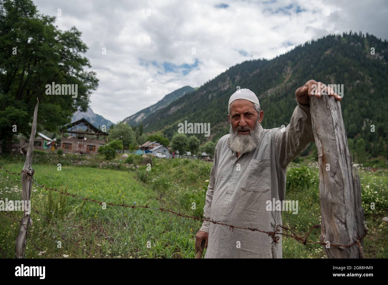 Bandipora, India. 18th July, 2021. A man looks on as he works in 