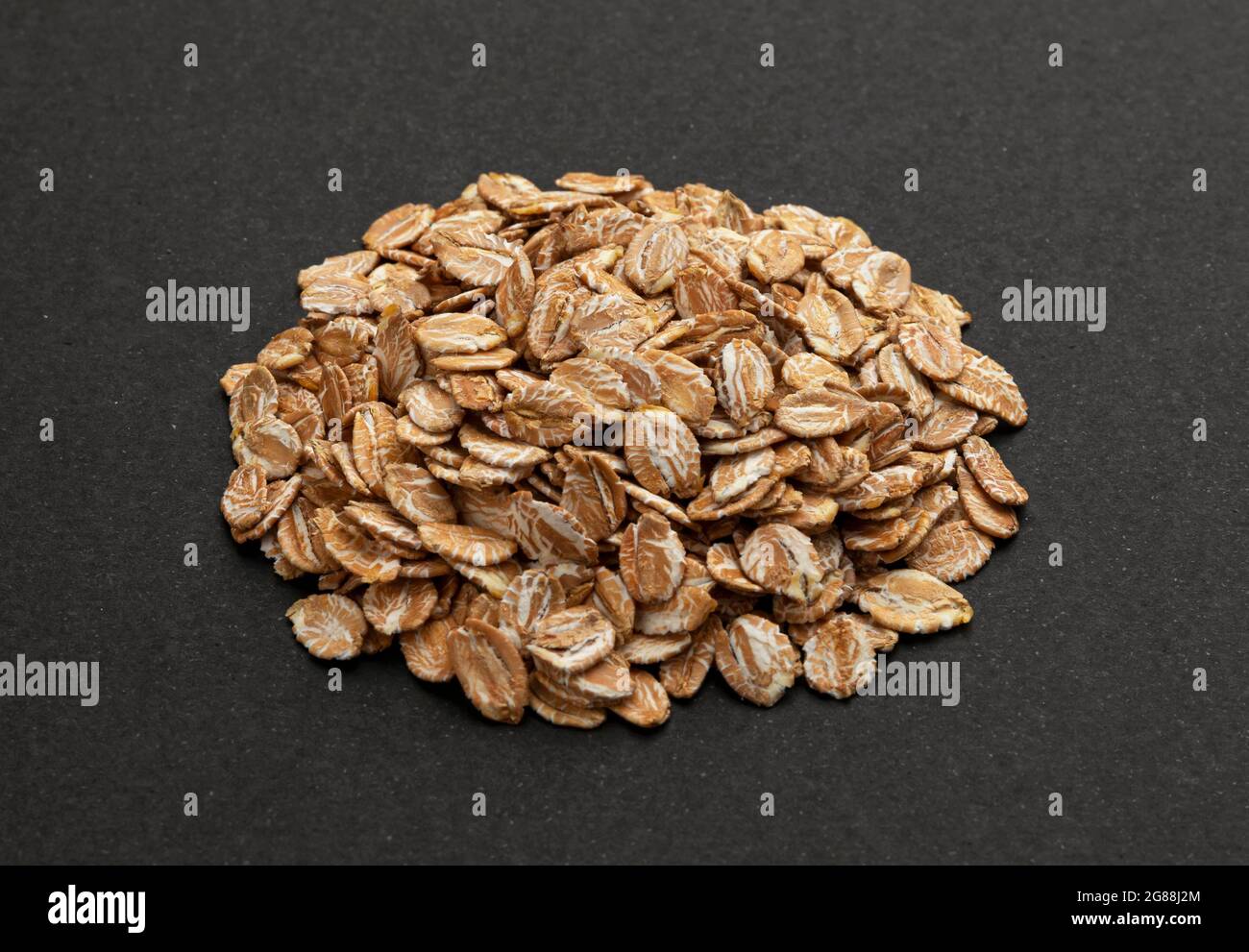 Top view of oat flakes on black background Stock Photo
