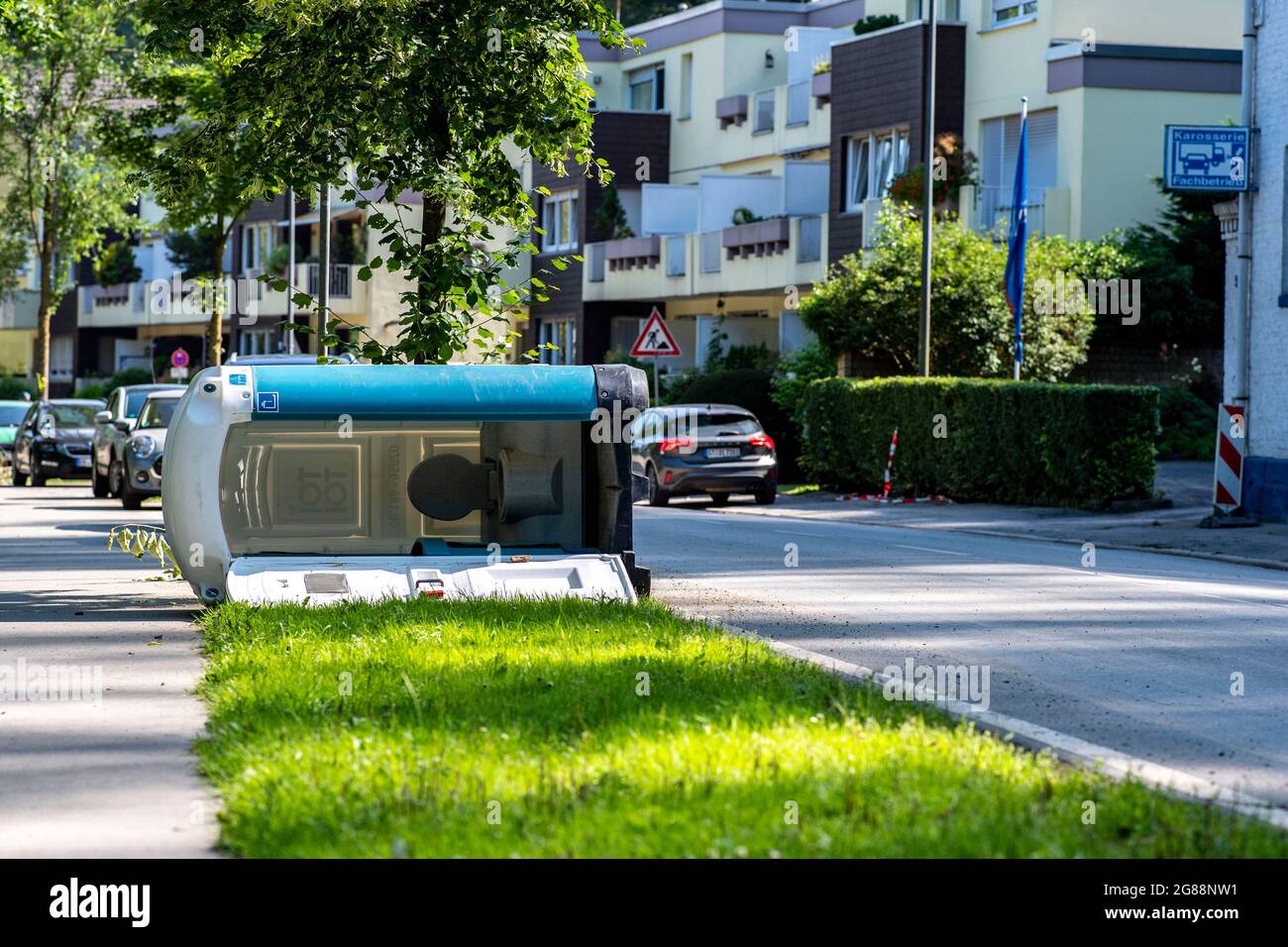Essen, Germany. 18th July, 2021. A mobile toilet house has fallen down at the Laupendahler Landstraße. On 15.07.2021 the nearby Ruhr overflowed its banks and flooded the district of Werden. Now the clean-up work has begun. Credit: David Inderlied/dpa/Alamy Live News Stock Photo