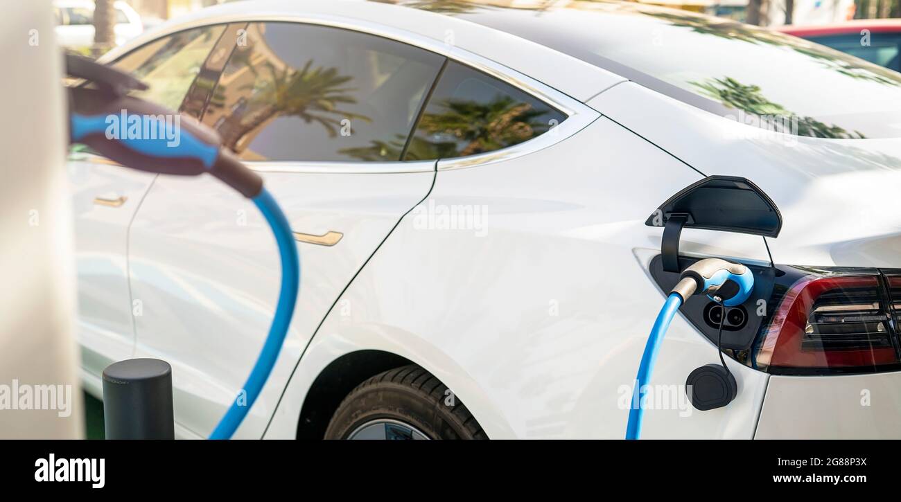 Electric Car parked at electric charging station Stock Photo