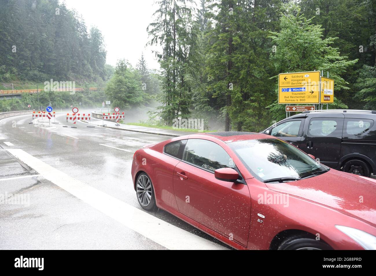18 July 2021, Bavaria, Königssee: A car turns around at the road towards Königssee, which was closed, during thunderstorm and high water in Bavaria in the Berchtesgadener Land. Photo: Felix Hörhager/dpa Stock Photo