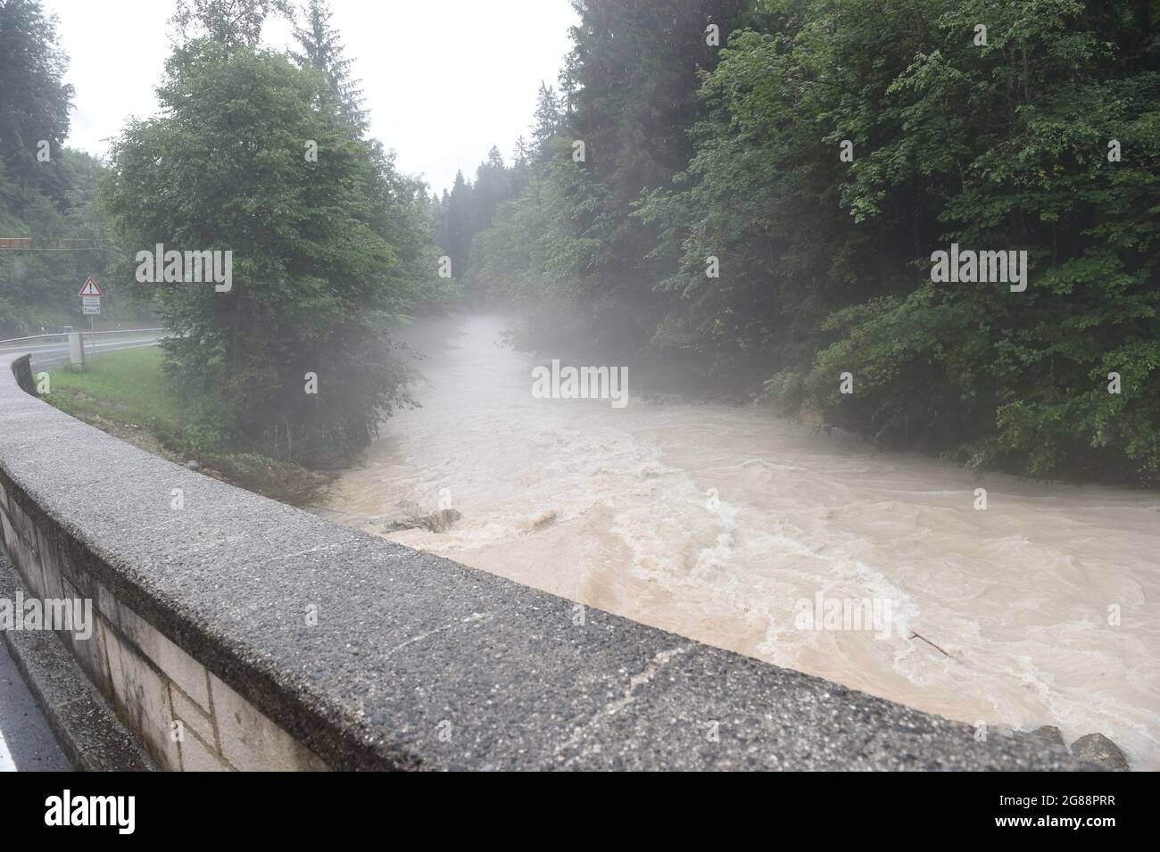 18 July 2021, Bavaria, Königssee: A river on the road to Königssee is flooded during storms and high water in Bavaria's Berchtesgadener Land region. Photo: Felix Hörhager/dpa Stock Photo