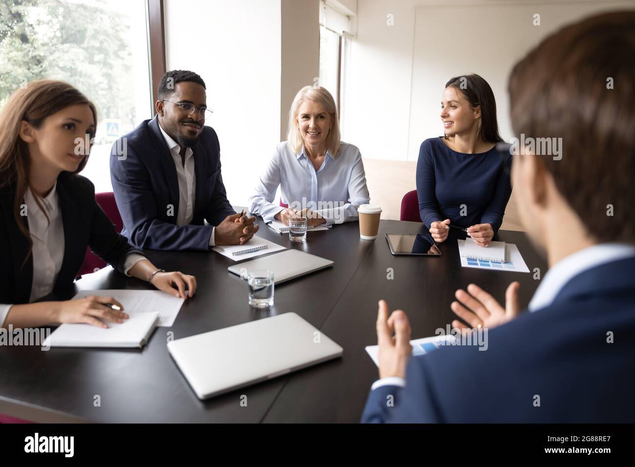 Mentor, coach talking to employees, giving training, discussing marketing reports Stock Photo