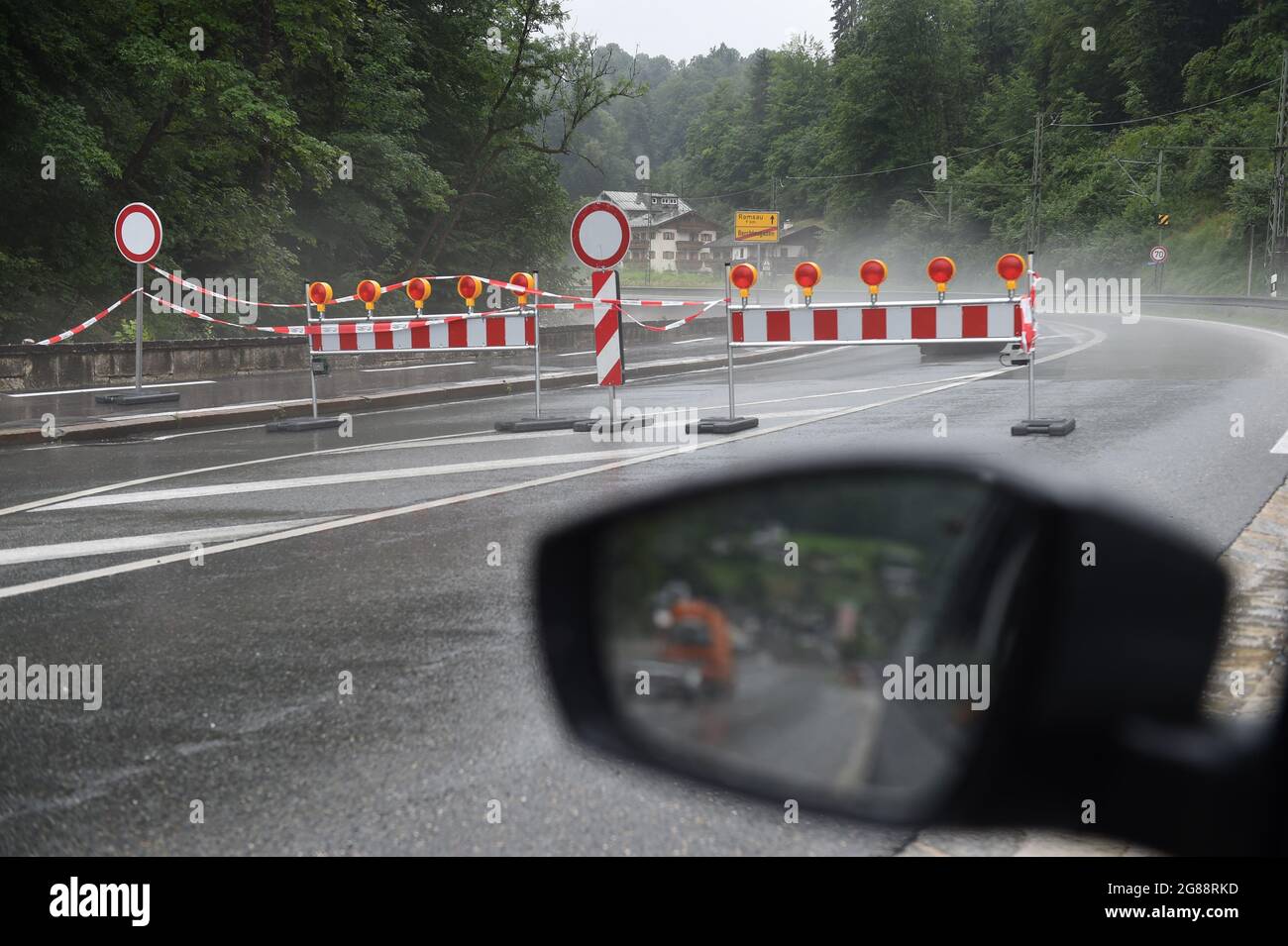 18 July 2021, Bavaria, Königssee: A barrier is seen on the road towards Ramsau, which was closed, during severe weather and flooding in Bavaria's Berchtesgadener Land region. Photo: Felix Hörhager/dpa Stock Photo