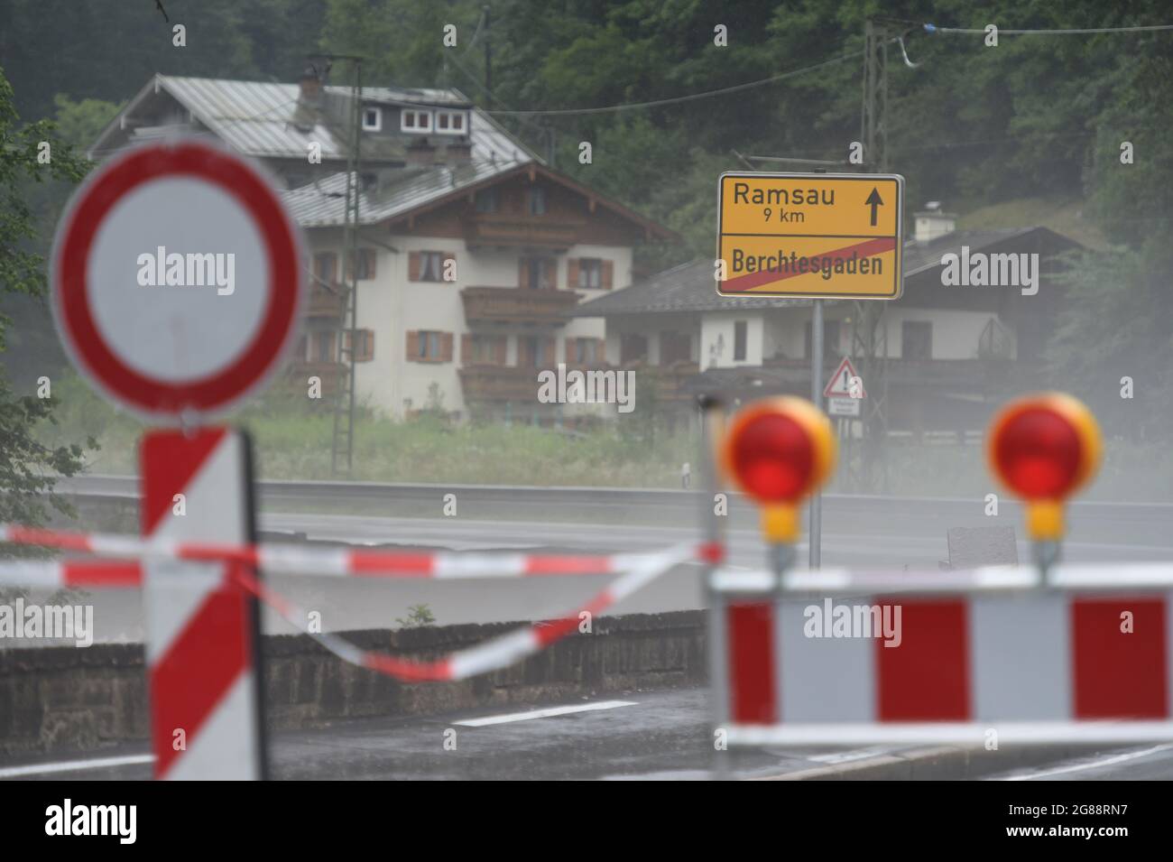 18 July 2021, Bavaria, Königssee: A barrier is seen on the road towards Ramsau, which was closed, during severe weather and flooding in Bavaria's Berchtesgadener Land region. Photo: Felix Hörhager/dpa Stock Photo