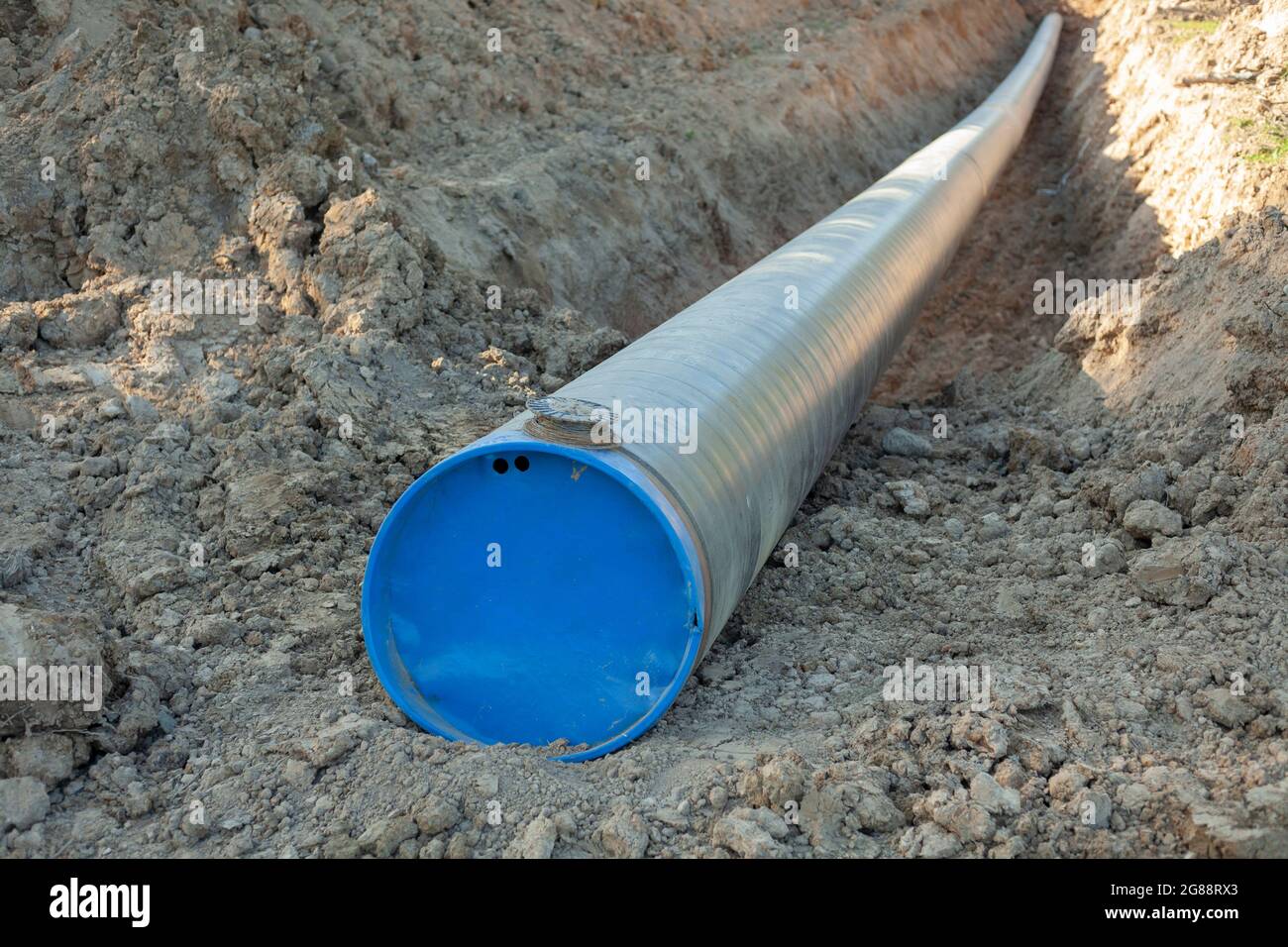 A big pipe for oil. The pipe burrows into the ground. Industrial transport  of fuel. Laying communications. Digging into the ground infrastructure  Stock Photo - Alamy