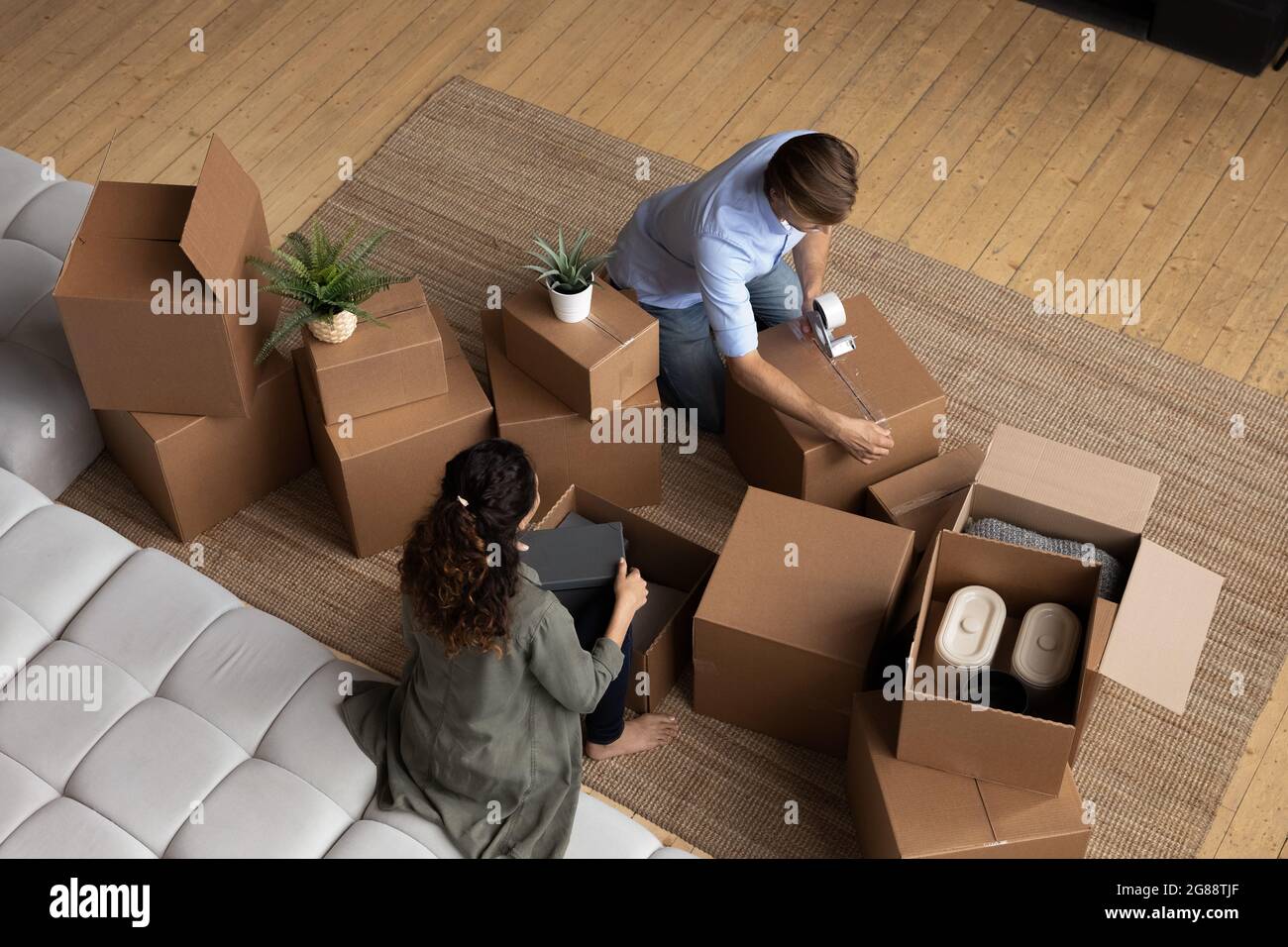 Happy young family couple engaged in packing belongings to boxes Stock Photo