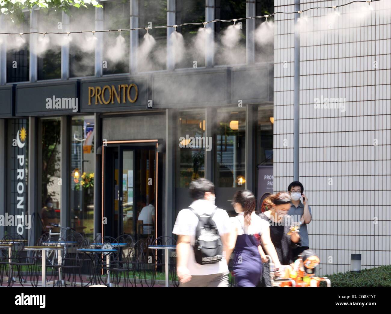 July 18, 2021, Tokyo, Japan - Pedestrians get water mist shower to cool down in Tokyo on Sunday, July 18, 2021. Tokyo's temperature soared over 32 degree Celsius after the rainy season was finished.    (Photo by Yoshio Tsunoda/AFLO) Stock Photo