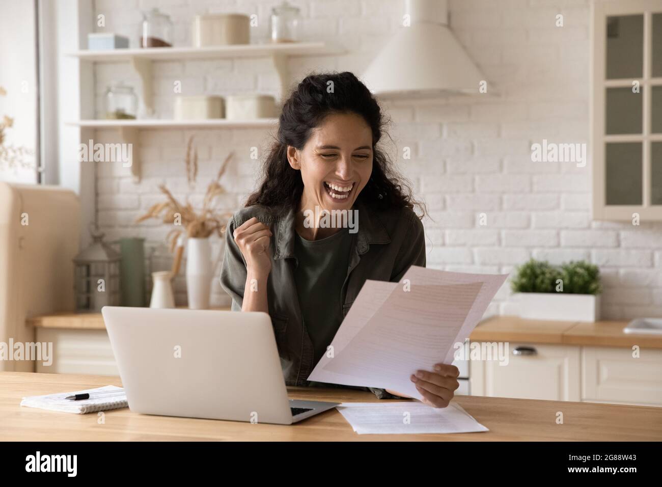 Overjoyed young latin lady get loan approval in bank letter Stock Photo