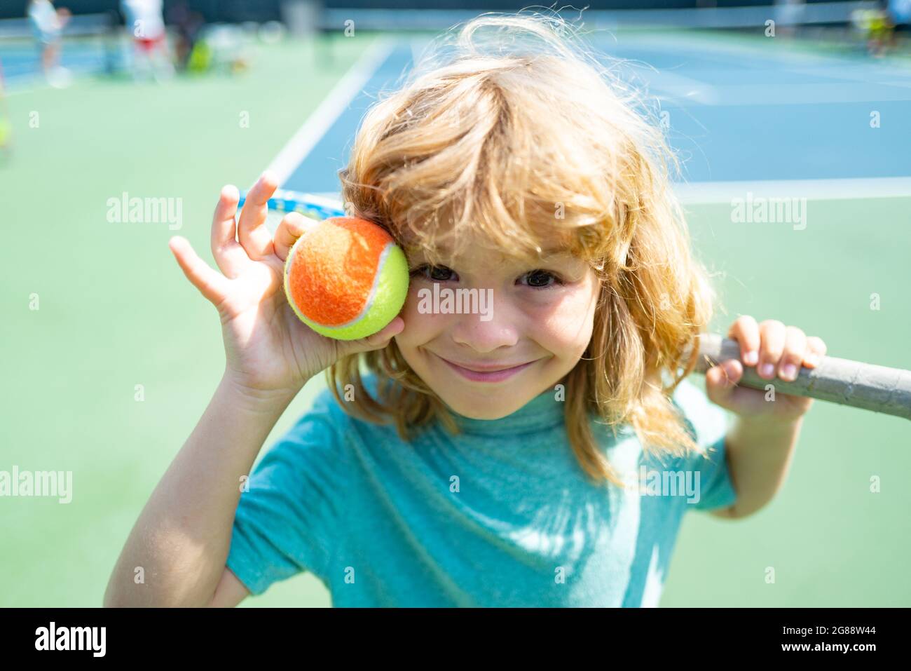 Kid tennis player on tennis court with racket and balls Stock Photo Alamy