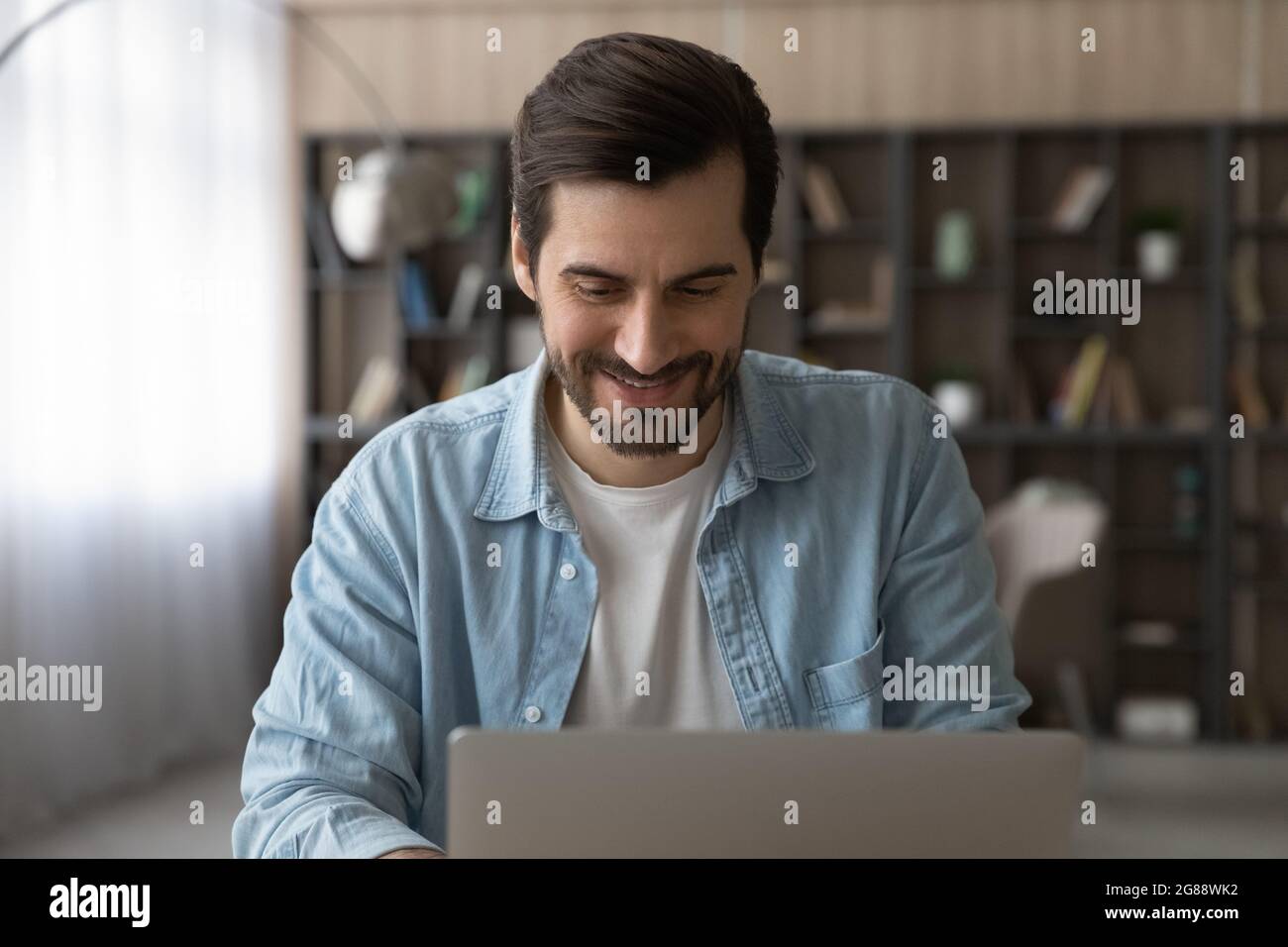 Happy young caucasian man working on computer. Stock Photo