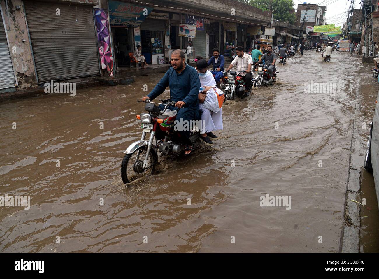 Lahore, Pakistan. 18th July, 2021. Pakistani Commuters Wade Through A 