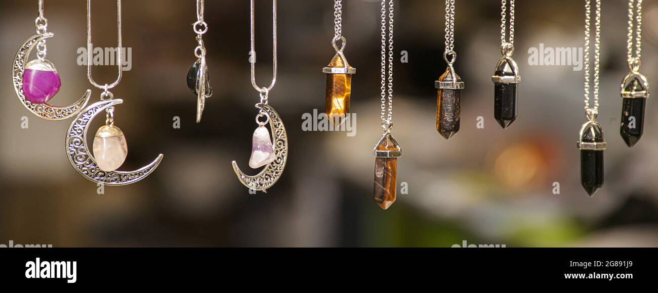 Miscellaneous silver necklaces of various shapes and colors set with  colored stones on blurred background, banner image with copy space Stock  Photo - Alamy