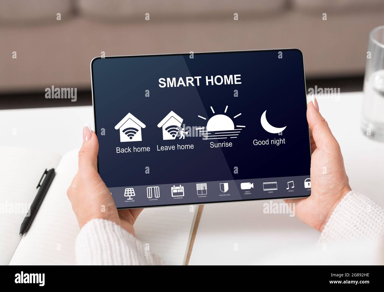 Woman controlling smart home with devices using digital tablet with ...