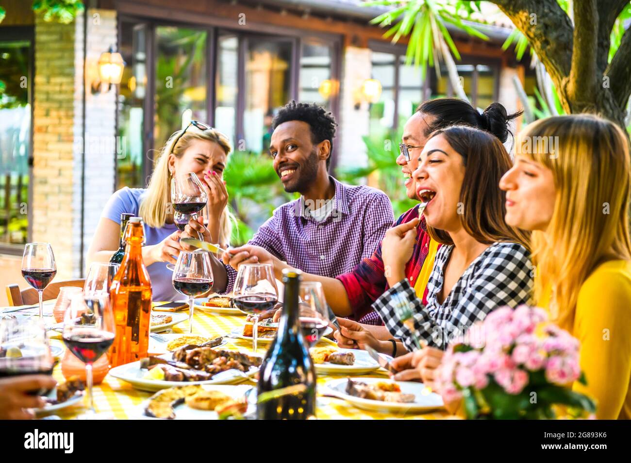 Group of happy multiracial friends having dinner in the restaurant