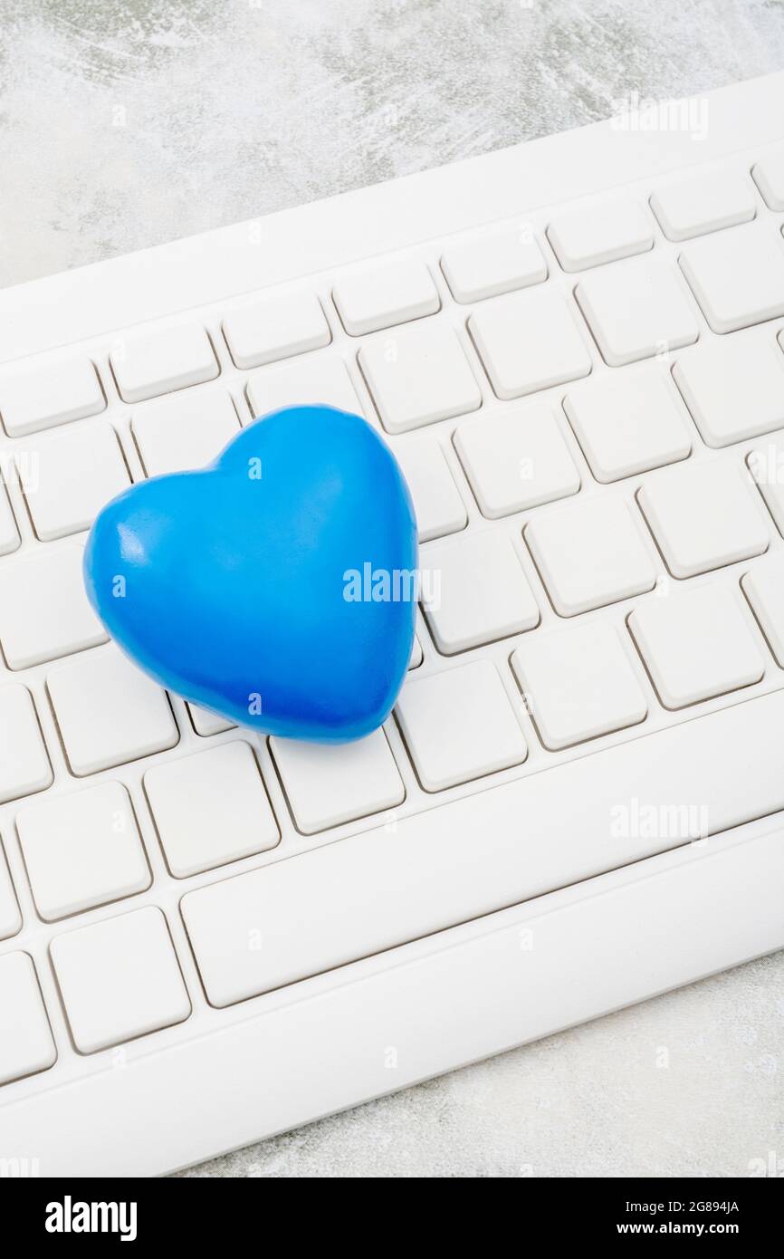 Blue heart + white Qwerty keyboard for Blue Monday, feeling gloomy /  dispirited, poor office morale, being dumped online, Covid lockdown mental  blues Stock Photo - Alamy