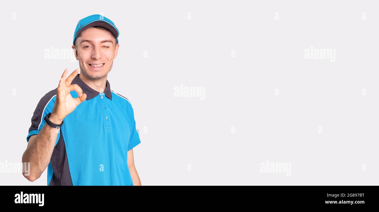 Photo of a smiling delivery man standing in front of camera showing ...